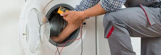 Dryer repair technician inspecting and repairing a clothes dryer in Stamford, CT