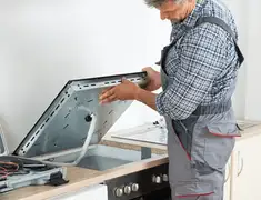 Appliance repair technician installing a built-in cooktop in Stamford, CT