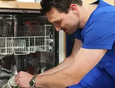 Dishwasher repair technician inspecting and servicing an open dishwasher in Stamford, CT