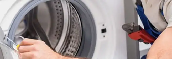 Appliance technician repairing a clothes dryer drum and internal parts in Stamford, CT