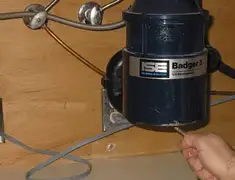 Garbage disposal repair technician tightening the mounting ring under a sink in Stamford, CT