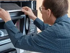 Appliance repair technician replacing a microwave vent filter in Stamford, CT