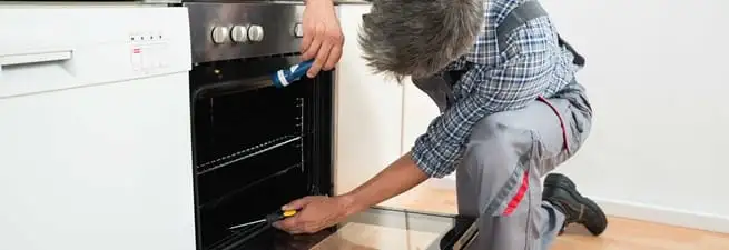 Oven repair technician inspecting and servicing an electric oven in Stamford, CT