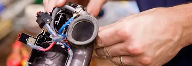 Vacuum repair technician reconnecting wiring and components in Stamford, CT