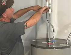 Water heater repair technician tightening supply line connections in Stamford, CT